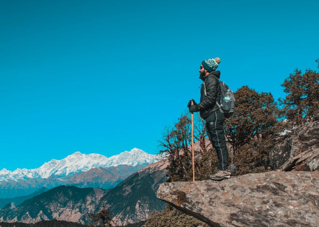 Man wearing mountaineering shoes for outdoor activities while staring in front of the horizon.