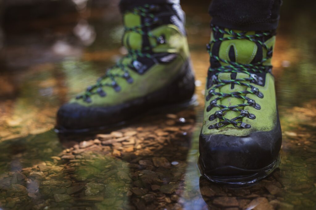 Learn how to clean hiking boots like this green one worn by a man.